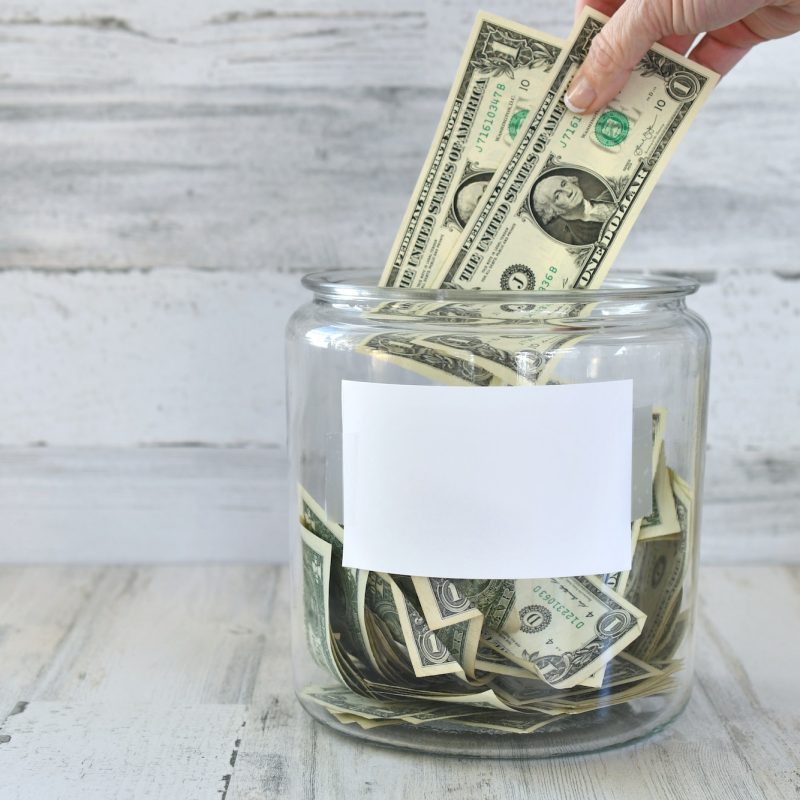 jar-of-money-cash-for-donation-fundraiser-fundraising-collection-hand-in-frame-blank-copy-space.jpg